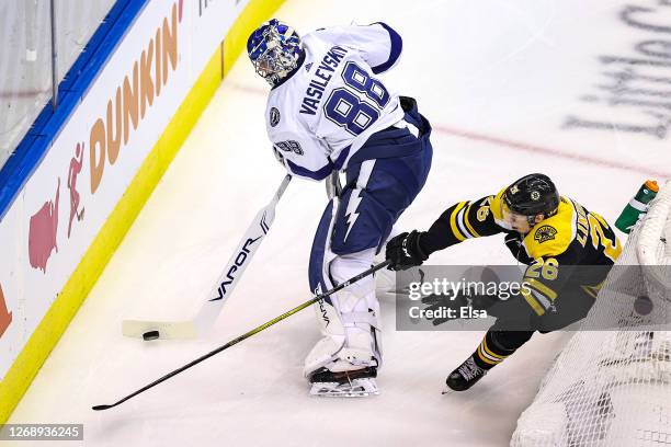 Andrei Vasilevskiy of the Tampa Bay Lightning attempts to clear the puck away Par Lindholm of the Boston Bruins during the first period in Game Three...