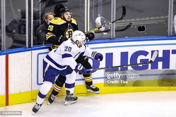Par Lindholm of the Boston Bruins is checked into the boards by Blake Coleman of the Tampa Bay Lightning during the first period in Game Three of the...