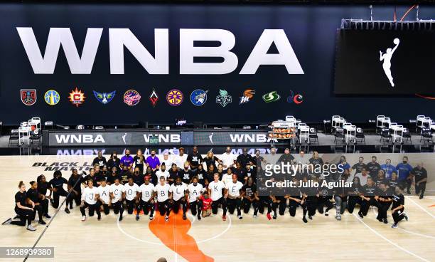 The Atlanta Dream, Washington Mystics, Minnesota Lynx, and the Los Angeles Sparks kneel on the court after the teams collectively decided to postpone...