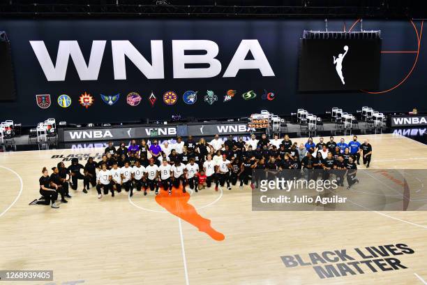The Atlanta Dream, Washington Mystics, Minnesota Lynx, and the Los Angeles Sparks kneel on the court after the teams collectively decided to postpone...