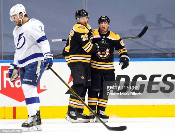 Brad Marchand of the Boston Bruins celebrates his power play goal against the Tampa Bay Lightning with teammate Patrice Bergeron during the second...