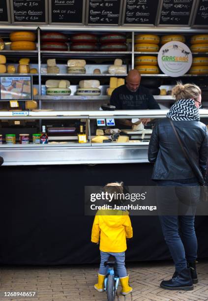 bolsward, freisland, holland: moeder en dochter bij cheese stand - familie fietsen close up stockfoto's en -beelden