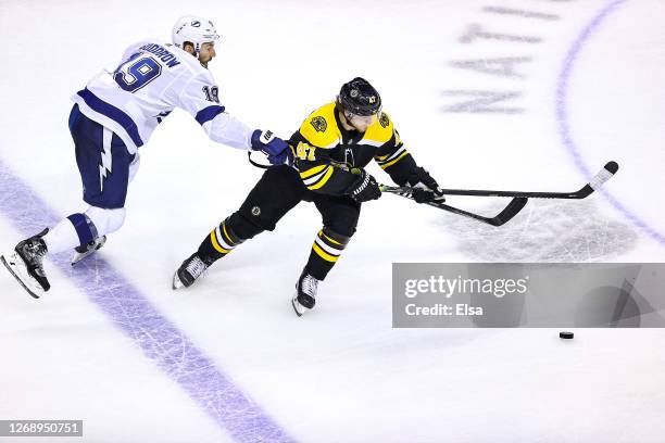 Torey Krug of the Boston Bruins is defended by Barclay Goodrow of the Tampa Bay Lightning during the third period in Game Three of the Eastern...
