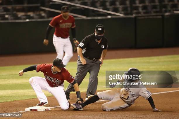 Infielder Nick Ahmed of the Arizona Diamondbacks tags out Garrett Hampson of the Colorado Rockies as he slides into third base during the sixth...