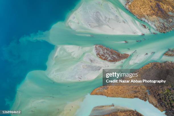 aerial view of river flowing into lake. - otago landscape stock pictures, royalty-free photos & images