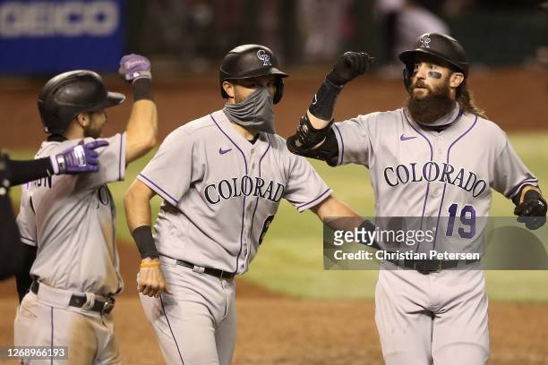 Charlie Blackmon of the Colorado Rockies is congratulated by Garrett Hampson and Drew Butera after hitting a grand-slam home run against the Arizona...
