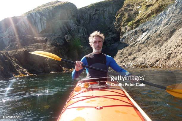older man kayaking on sea - sea kayaking imagens e fotografias de stock