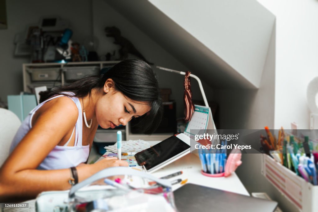 Female hispanic teenager doing some homeworks during online classes