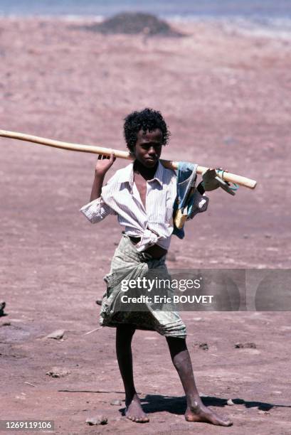 Adolescent tenant un bâton sur ses épaules, circa 1980, Djibouti.