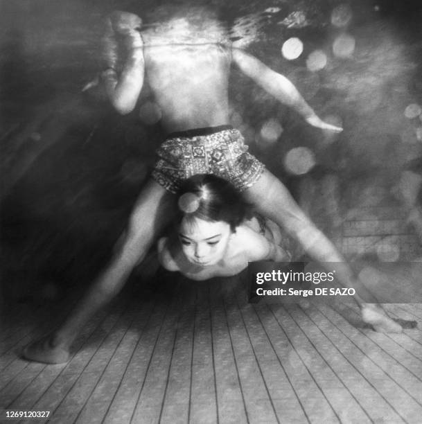 Enfant nageant sous l'eau dans une piscine, circa 1970, France.