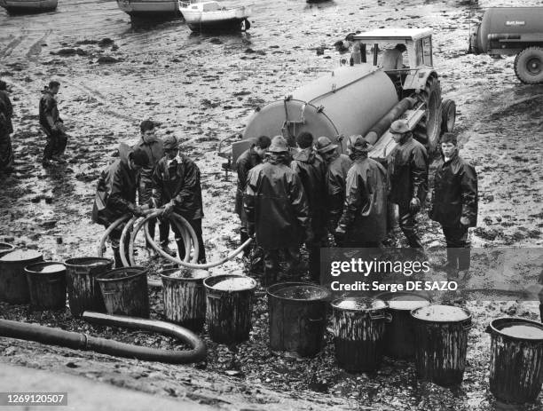 Pompage du mazout par l'armée dans le port de Portsall, après la marée noire causée par le naufrage de l''Amoco Cadiz', en mars 1978, dans le...