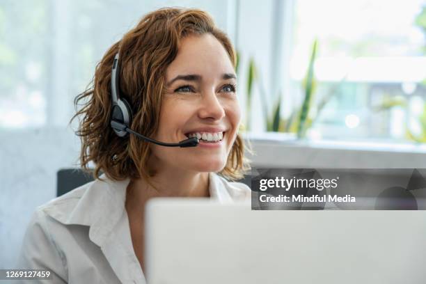 customer service representative wearing headset in the office - customer service stock pictures, royalty-free photos & images