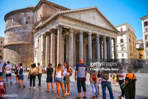 dozens of tourists wait patiently in line to visit the beautiful roman pantheon in the historic heart of rome - roman forum stock pictures, royalty-free photos & images
