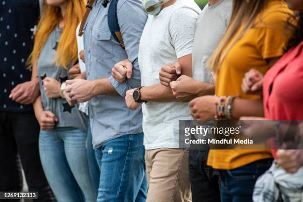 protestors standing together - arm in arm stock pictures, royalty-free photos & images