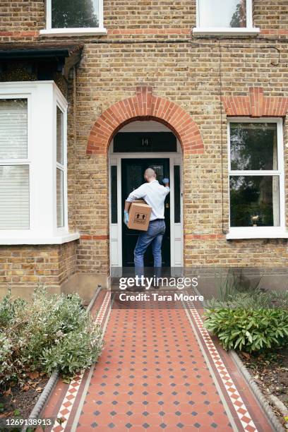 delivery person knocking on door at house - brick house stock pictures, royalty-free photos & images
