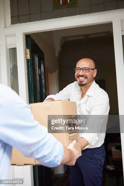 deliveryman delivering package to home owner - wine home delivery stock pictures, royalty-free photos & images