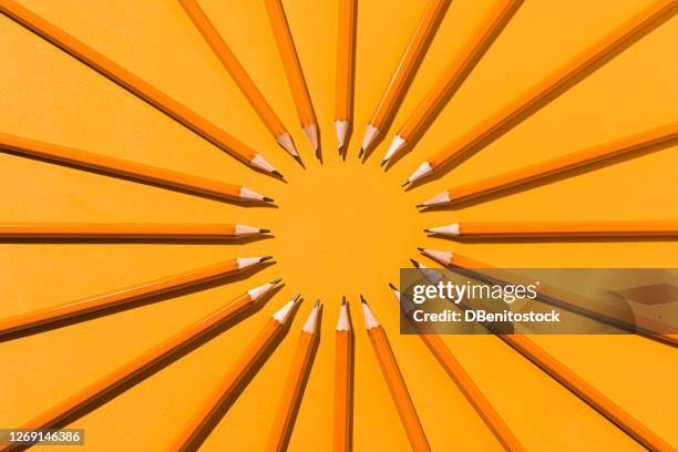 orange pencils forming a circle with their graphite tips on an orange background. college, meeting and office concept - pencil with rubber stock pictures, royalty-free photos & images