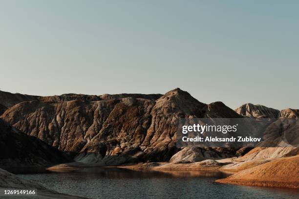 ural apocalyptic surreal unusual landscape, similar to the surface of the planet mars. the frozen red-brown surface of the earth. barren, cracked and scorched earth and soil. the concept of global warming. clay quarries. there is water or a river on mars. - apocalypse stock pictures, royalty-free photos & images