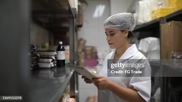 employee checking storage room using digital tablet - restaurant manager phone stock pictures, royalty-free photos & images