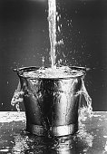 Black and white photo of Water pouring into a bucket