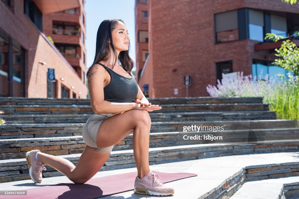 Young fit woman stretching after training.