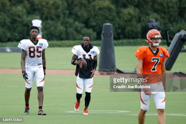 John Ross III and Tee Higgins of the Cincinnati Bengals look on during training camp workouts at the practice field outside Paul Brown Stadium on...