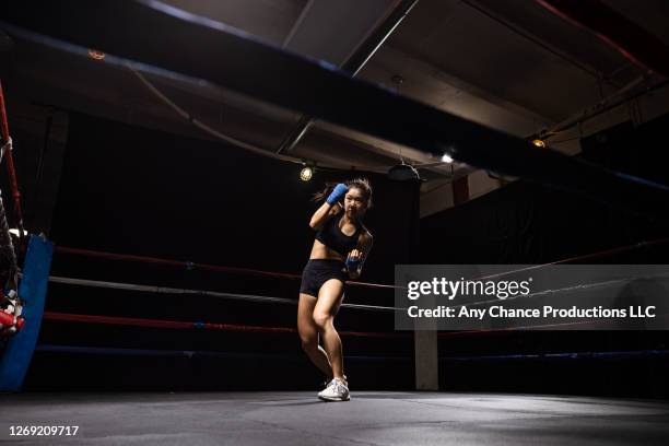 shadow boxing female traing alone in a ring. - boxing - women's stock pictures, royalty-free photos & images