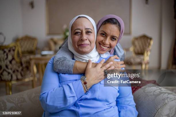 madre e figlia adulta in salotto - muslim family foto e immagini stock