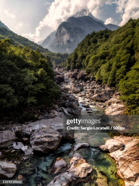 scenic view of stream flowing through rocks against sky, lavertezzo, switzerland - valle verzasca stock-fotos und bilder