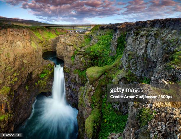 scenic view of waterfall against sky, akureyri, iceland - akureyri iceland stockfoto's en -beelden