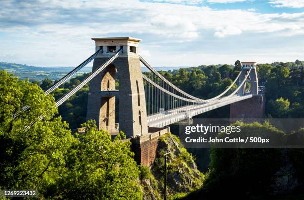view of suspension bridge against cloudy sky, bristol, united kingdom - bristol stock-fotos und bilder
