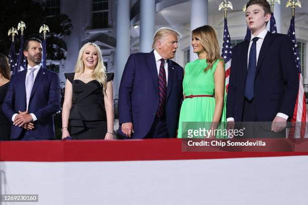 President Donald Trump speaks with first lady Melania Trump as they stand with family members after delivering his acceptance speech for the...