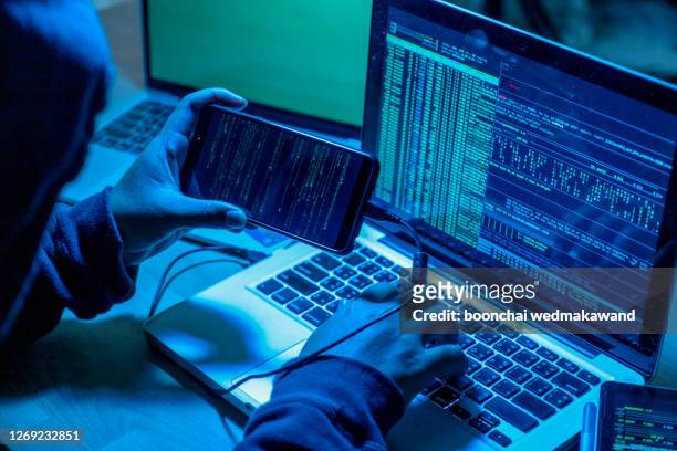 hacker with computers in dark room. cyber crime - stealing crime ストックフォトと画像