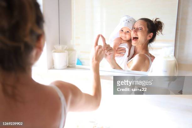 badezeit - mother and baby taking a bath stock-fotos und bilder