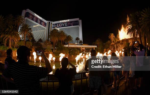 Visitors watch as the volcano attraction in front of The Mirage Hotel & Casino erupts after the Las Vegas Strip resort reopened for the first time...