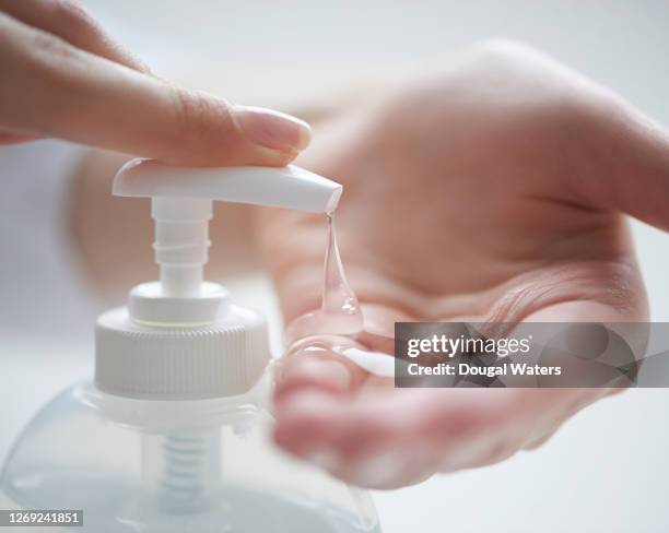 female hand dispensing hand sanitiser gel, close up. - hand sanitizer imagens e fotografias de stock