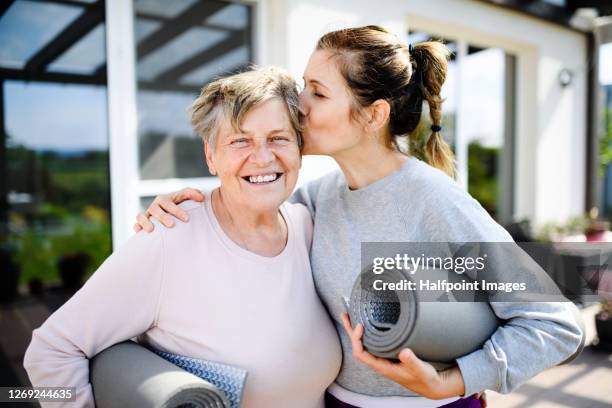 portrait of woman with senior mother resting after exercise outdoors. - family exercising stock-fotos und bilder