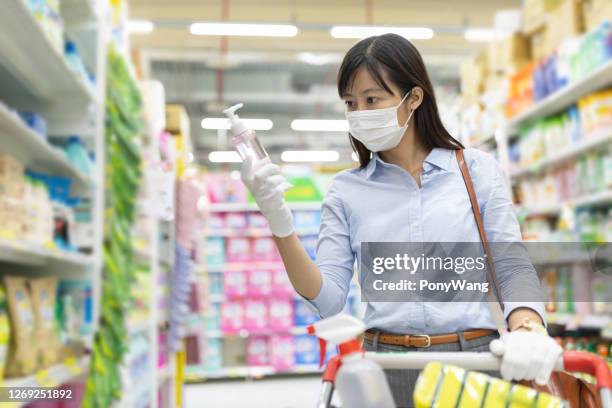 asian woman buy cleaning supplies - sanitizing products stock pictures, royalty-free photos & images