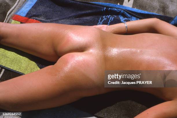 Nudiste enduit de crème solaire en août 1993 dans l'Hérault, France.