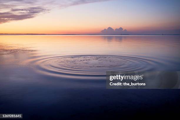 rings in water of the sea and reflection of the sky during sunset - jewellery background stock pictures, royalty-free photos & images