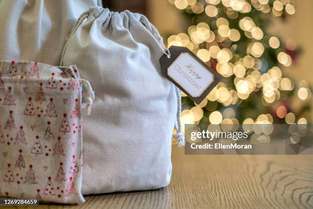 christmas gift in a reusable bag - christmas gift bag stock pictures, royalty-free photos & images