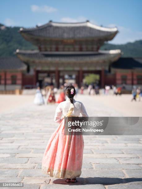 asian tourist in hanbok in gyeongbokgung palace, seoul, korea - korea palace stock pictures, royalty-free photos & images