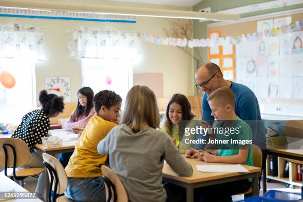 teacher with children in classroom - elementary school stockfoto's en -beelden