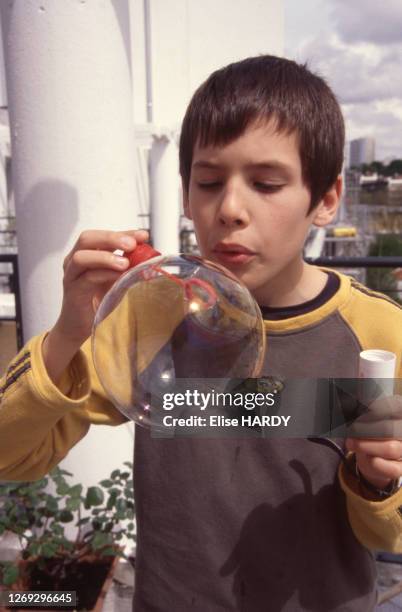 Enfant soufflant dans une bulle de savon géante, circa 1990, France.