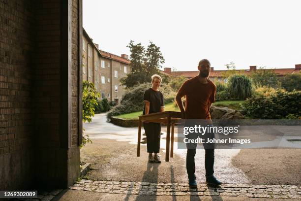 couple carrying table - outdoor furniture stock pictures, royalty-free photos & images