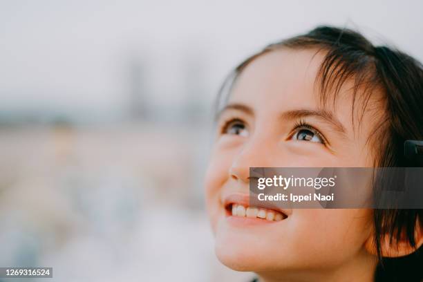 beautiful young mixed race girl looking up at sky - kid looking up to the sky imagens e fotografias de stock