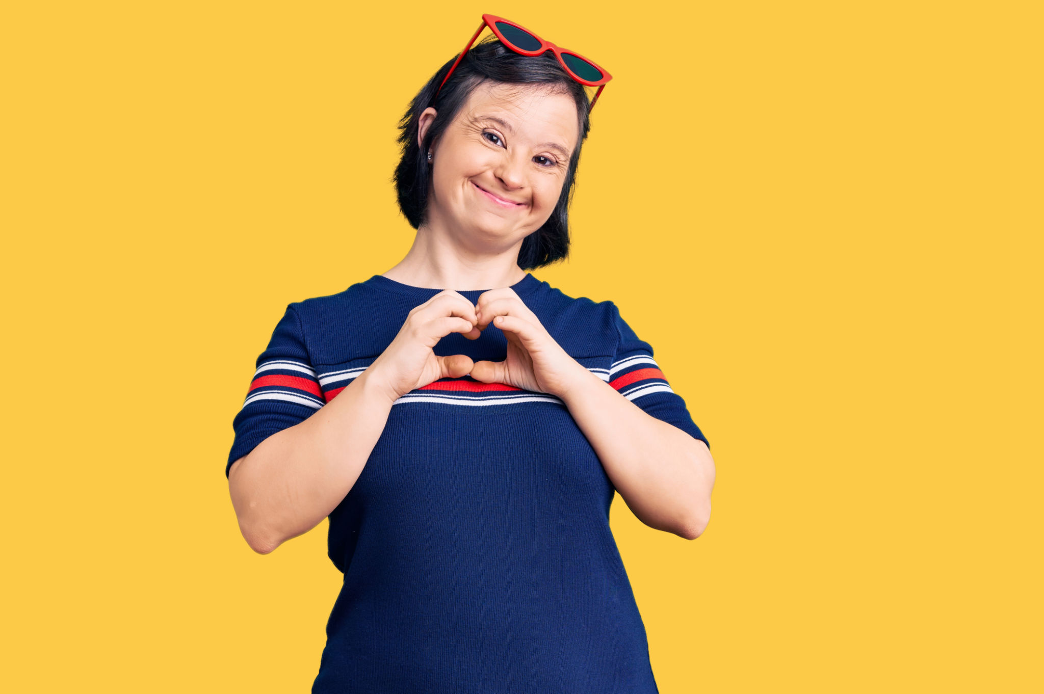 Brunette woman with down syndrome wearing casual clothes smiling in love showing heart symbol and shape with hands. romantic concept. Brunette woman with down syndrome wearing casual clothes smiling in love showing heart symbol and shape with hands. romantic concept.