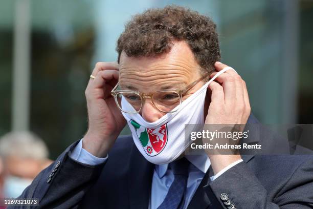 German Health Minister Jens Spahn puts on a face mask before visiting a tent used for coronavirus testing at the Bethanien hospital on August 28,...