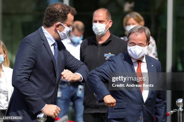 German Health Minister Jens Spahn greets North Rhine-Westphalia Governor Armin Laschet by bumping their ellbows ahead of a visit to a tent used for...