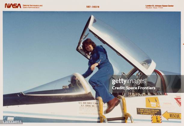 American physicist Sally Ride , wearing a blue NASA flight suit, egresses the cockpit of the Northrop T-38 Talon aircraft during training for her...